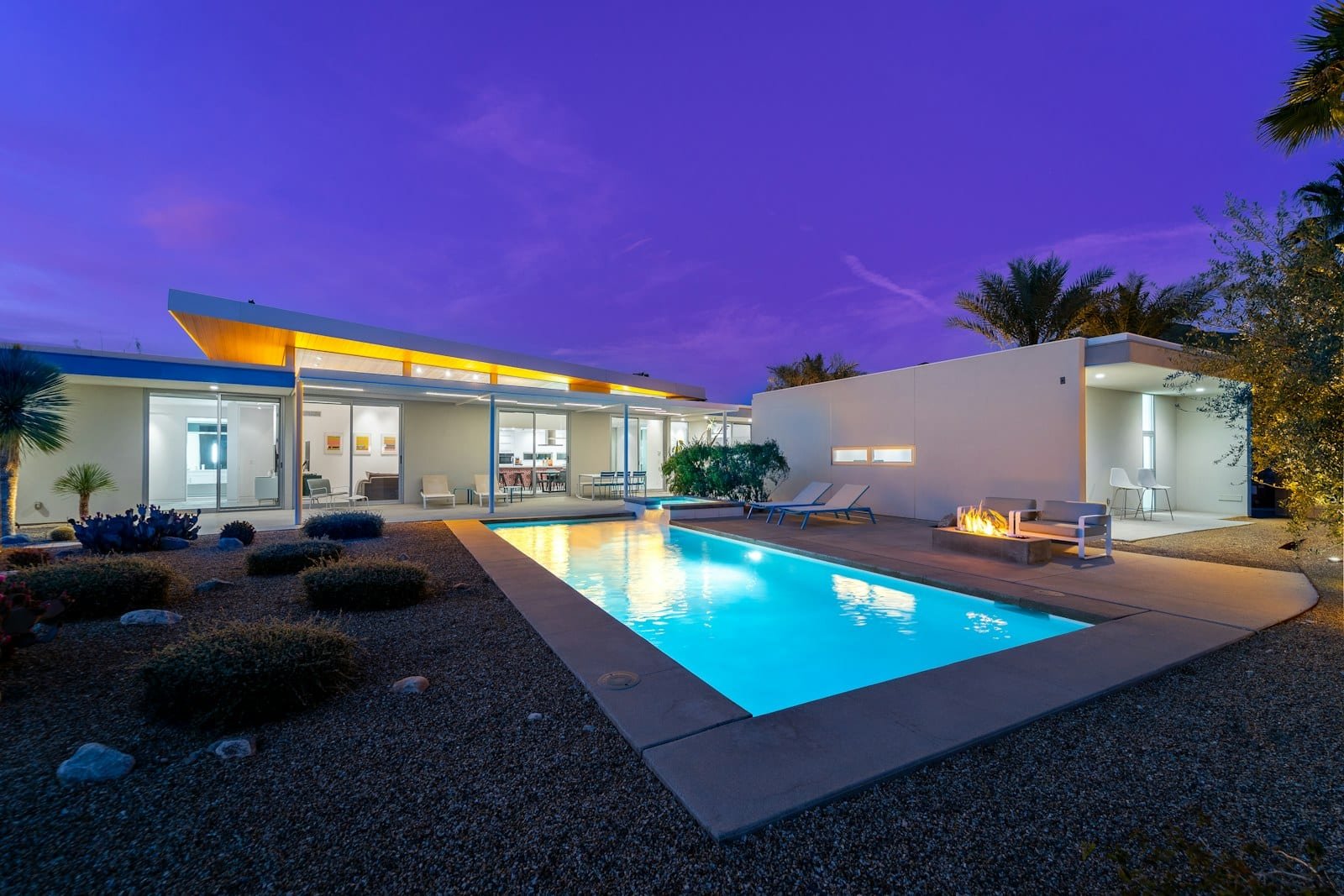 A villa exterior and pool lit through the evening, the kind of perimeter a security system keeps watch over
